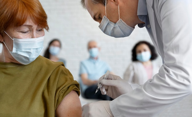 Mujer recibiendo vacuna inyectada por médico