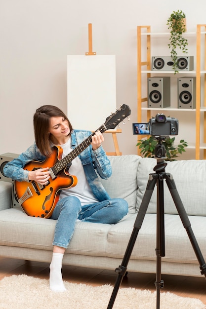 Mujer recodificando mientras toca la guitarra