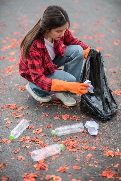 Foto gratuita mujer recogiendo basura en una bolsa negra.