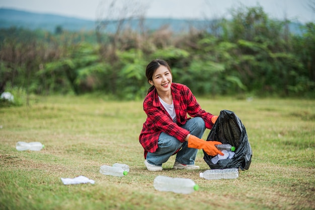 Mujer recogiendo basura en una bolsa negra.