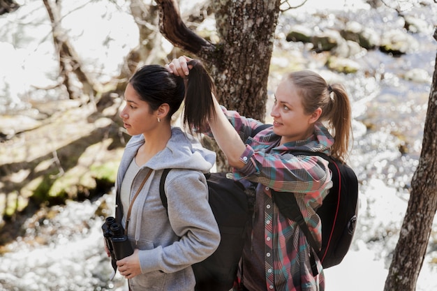 Mujer recogiendo el pelo de su amiga