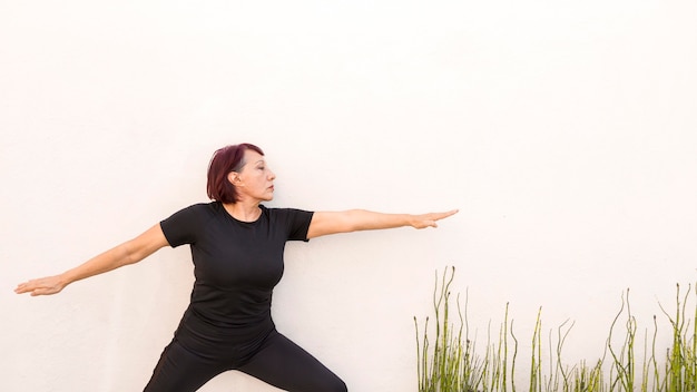 Foto gratuita mujer recostada en una pared y haciendo ejercicios