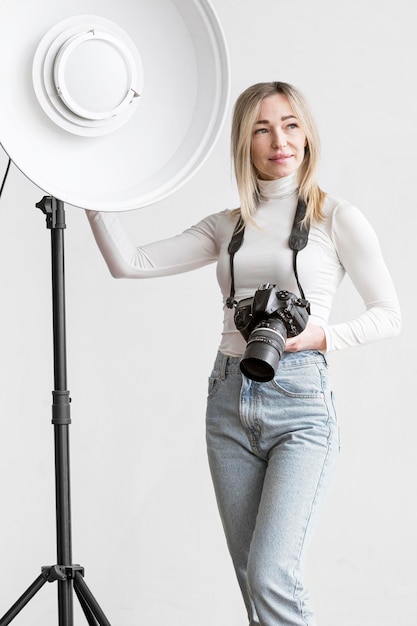 Foto gratuita mujer recostada sobre una lámpara de estudio