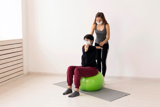 Mujer recuperándose después de tener covid en fitness ball