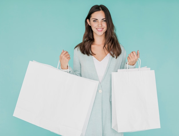 Mujer con redes de compras sobre fondo azul.