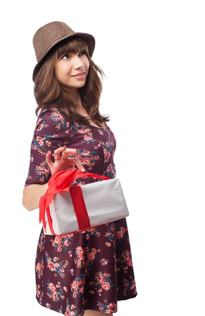 Mujer con un regalo en una mano y un sombrero
