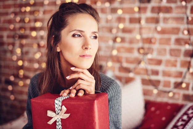 Foto gratuita mujer con regalo de navidad soñando