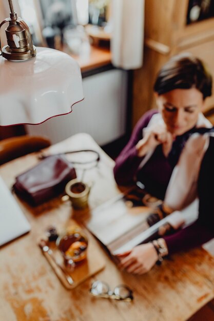 Mujer relajada disfrutando de una revista en un café