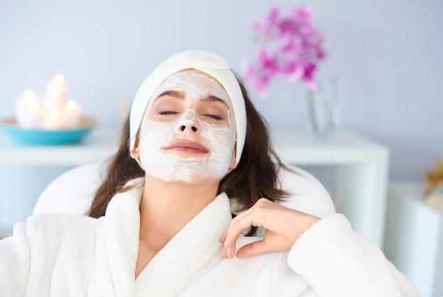 Mujer relajada está recibiendo una mascarilla en spa