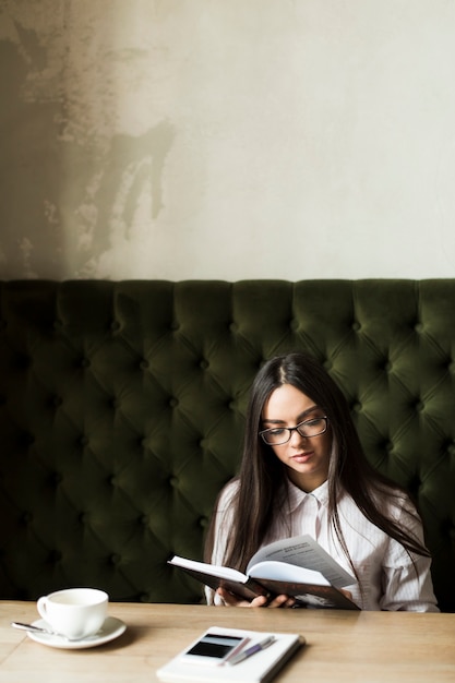 Foto gratuita mujer relajada con libro en café