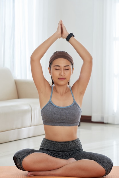 Mujer relajada meditando en casa