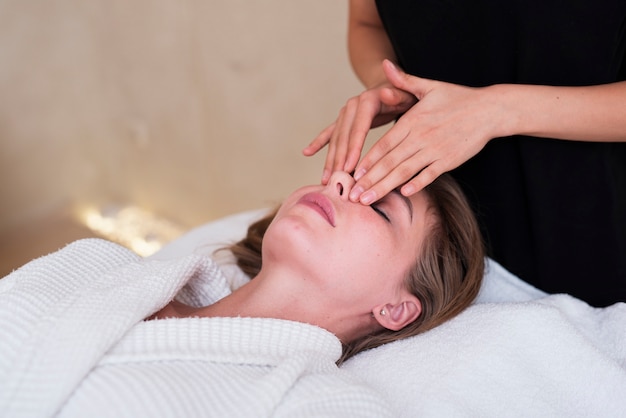 Mujer relajada recibiendo un masaje facial