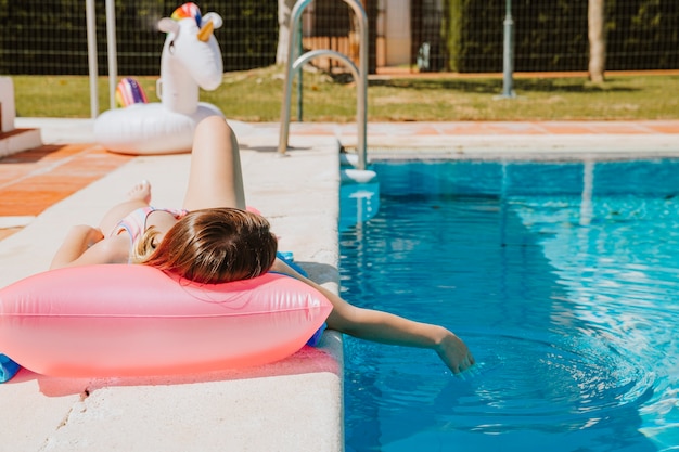 Mujer relajando al lado de piscina