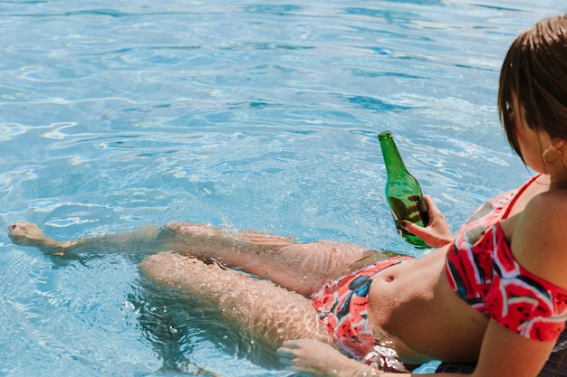 Mujer relajando al lado de piscina