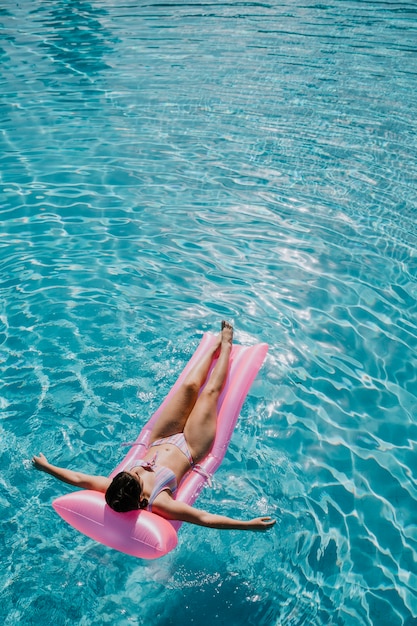 Mujer relajando en flotador en la piscina