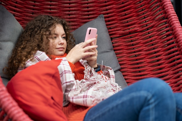 Foto gratuita mujer relajándose afuera con teléfono