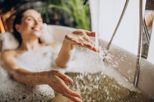 Mujer relajante en el baño con burbujas