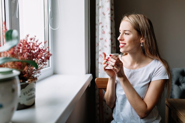 mujer relajante con café por la ventana