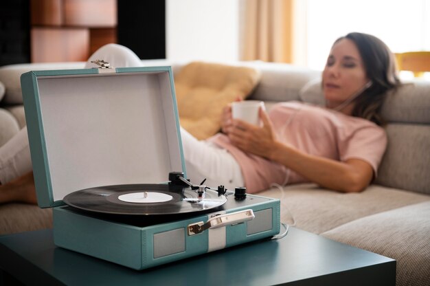 Mujer relajante en casa mientras escucha música en vinilo