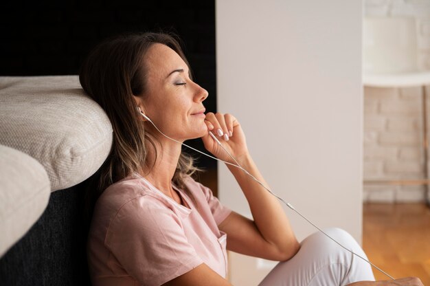 Mujer relajante escuchando música en casa