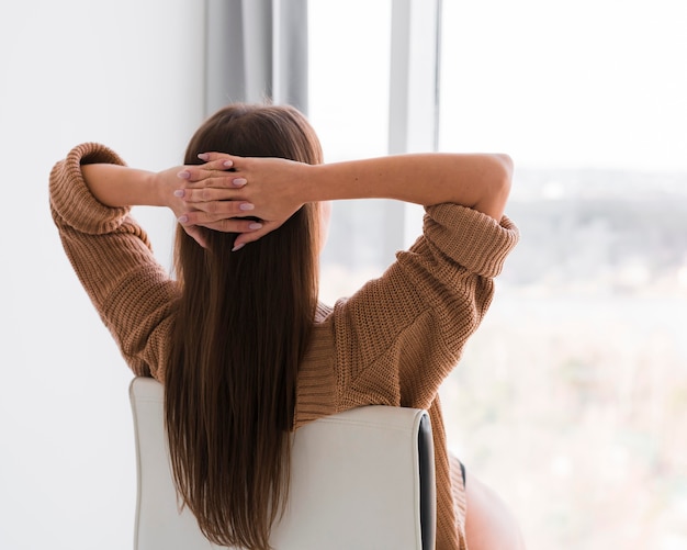 Mujer relajante y mirando por la ventana