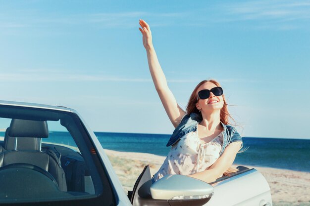 Mujer relajante en la playa en el coche