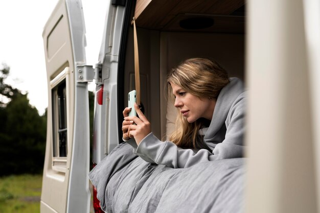 Mujer relajante en su caravana a la luz del día