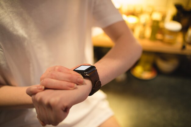 Mujer con reloj inteligente en casa