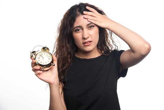 Mujer con reloj sosteniendo su cabeza sobre fondo blanco. Foto de alta calidad