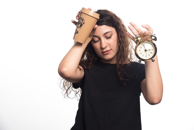 Foto gratuito mujer con reloj sosteniendo su cabeza y taza sobre fondo blanco. foto de alta calidad