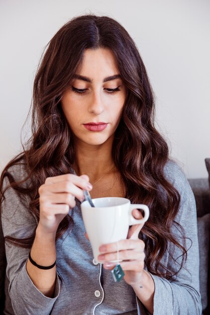 Mujer removiendo el azúcar en el té