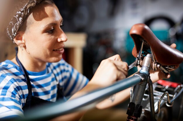 Mujer reparando bicicleta de cerca