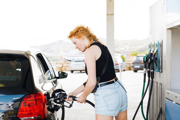 Foto gratuita mujer repostar coche con gasolina en gasolinera