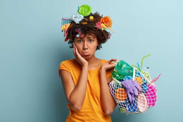 Foto gratuita mujer con residuos plásticos en bolsa de red