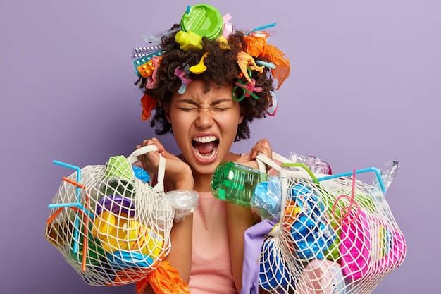 Mujer con residuos plásticos en bolsa de red