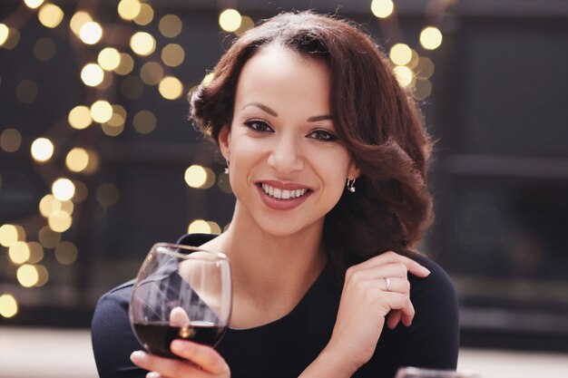 Mujer en restaurante sosteniendo una copa de vino