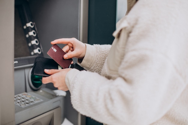 Foto gratuita mujer retirando dinero en cajeros automáticos fuera de la calle