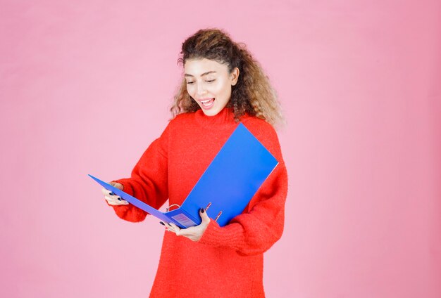 mujer revisando la carpeta del proyecto y se ve sorprendida.