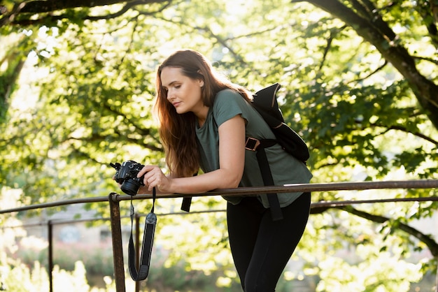 Foto gratuita mujer revisando las fotos que tomó con su cámara digital