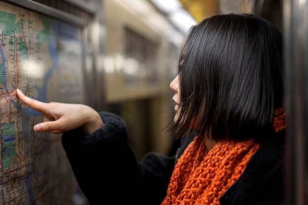 Mujer revisando el mapa en el metro de la ciudad