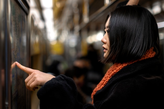 Mujer revisando el mapa en el metro de la ciudad