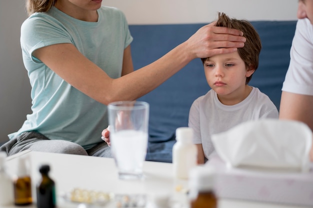 Mujer revisando a su hijo para la fiebre