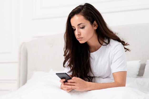 Mujer revisando su teléfono después de despertarse