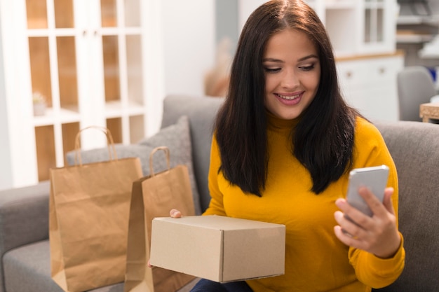 Mujer revisando su teléfono para una nueva compra en cyber monday