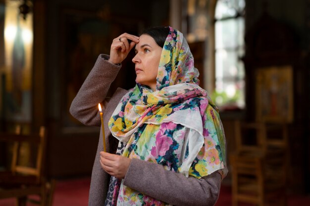 Mujer rezando en la iglesia para la peregrinación religiosa