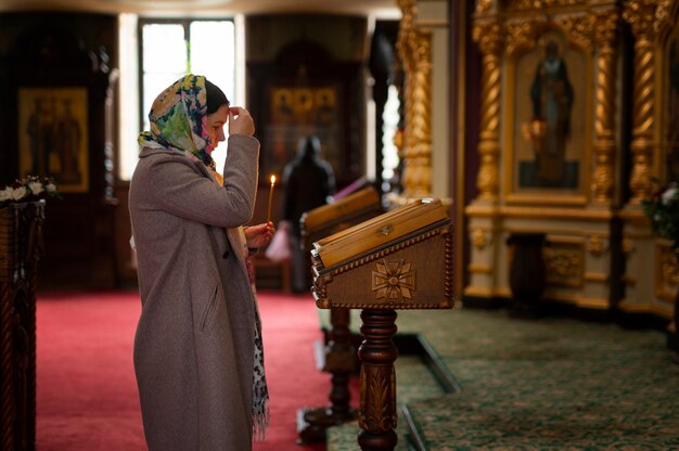 Mujer rezando en la iglesia para la peregrinación religiosa