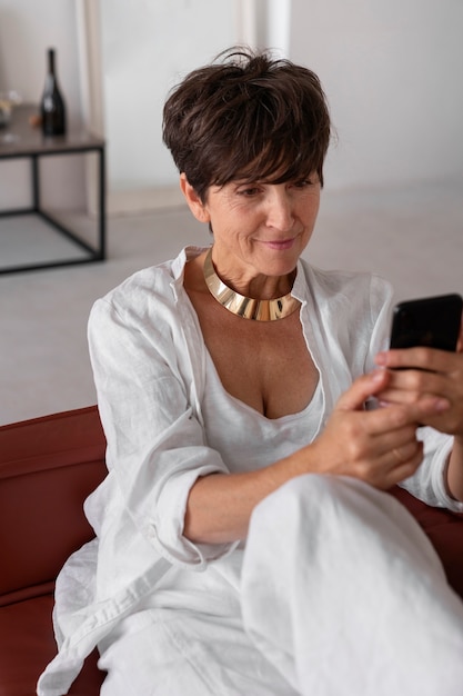 Foto gratuita mujer rica de tiro medio con teléfono inteligente