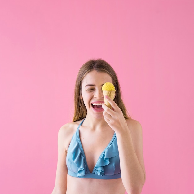 Mujer riendo en bikini con helado