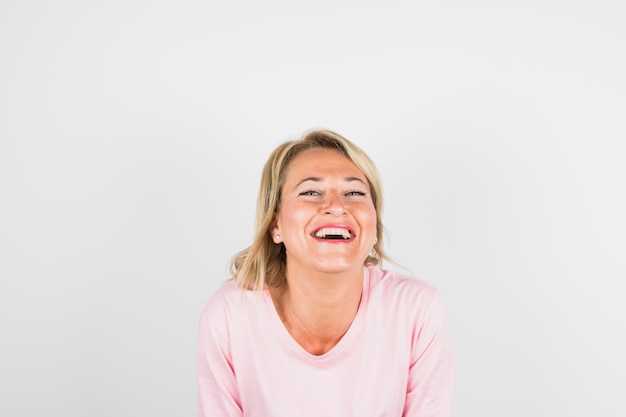 Mujer riendo envejecida en blusa rosa