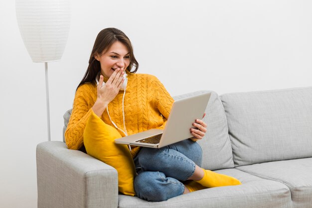 Mujer riéndose de algo gracioso que vio en su computadora portátil